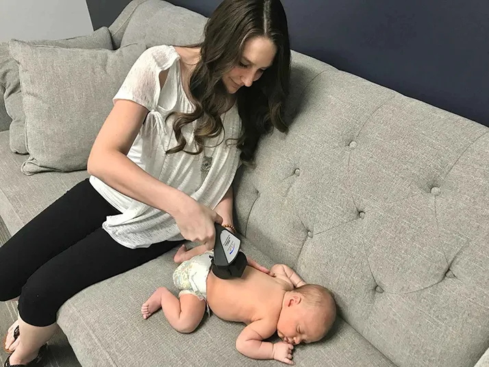 Chiropractic Edina MN Cami Wilson Scanning Baby On Couch